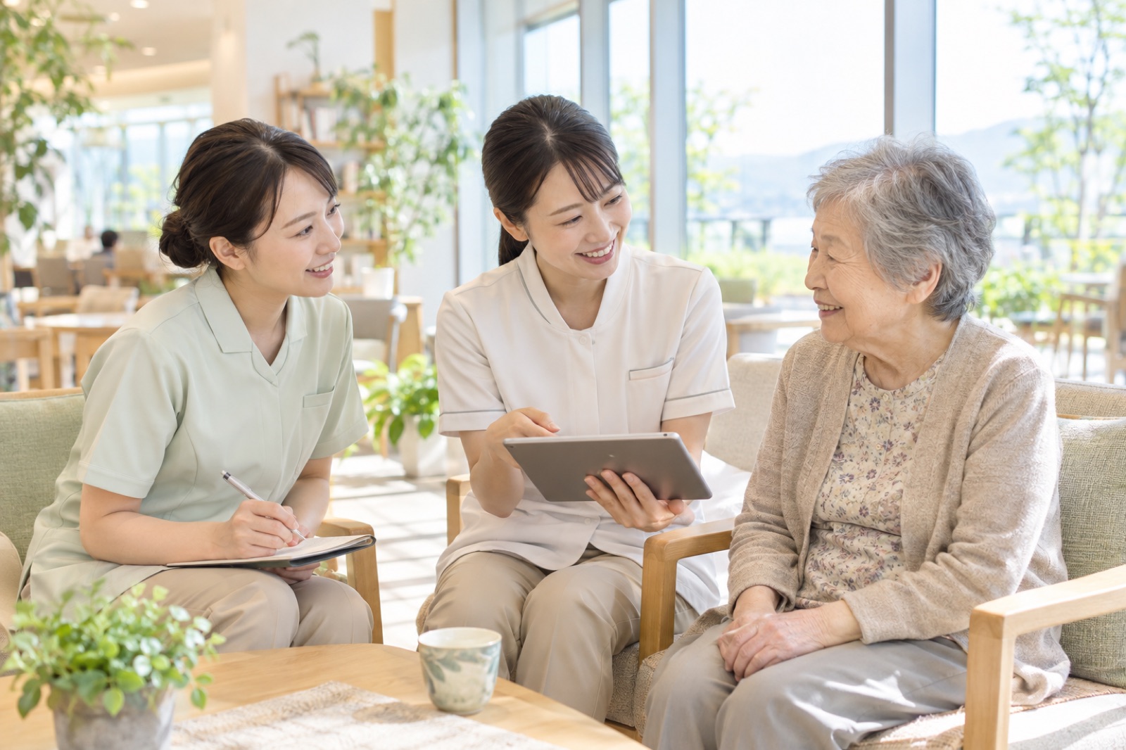 明るいラウンジで利用者さんを囲み話し合う介護スタッフたち